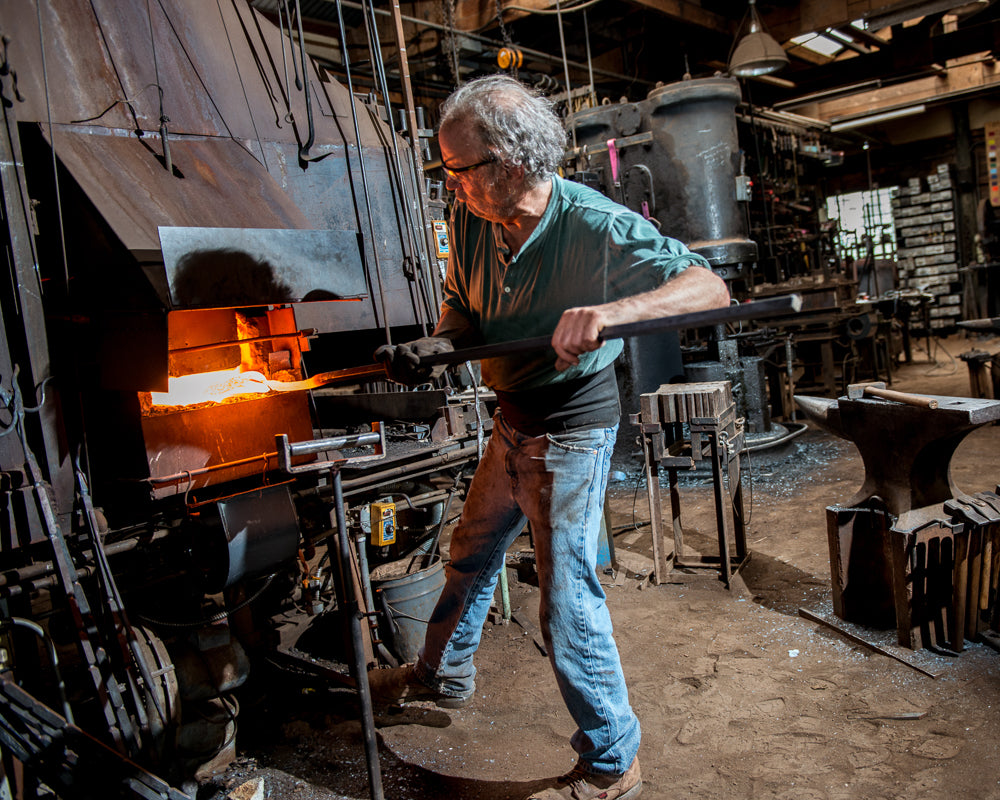 New Mexico blacksmith, Christopher Thomson, heating a metal rod at the iron forge.