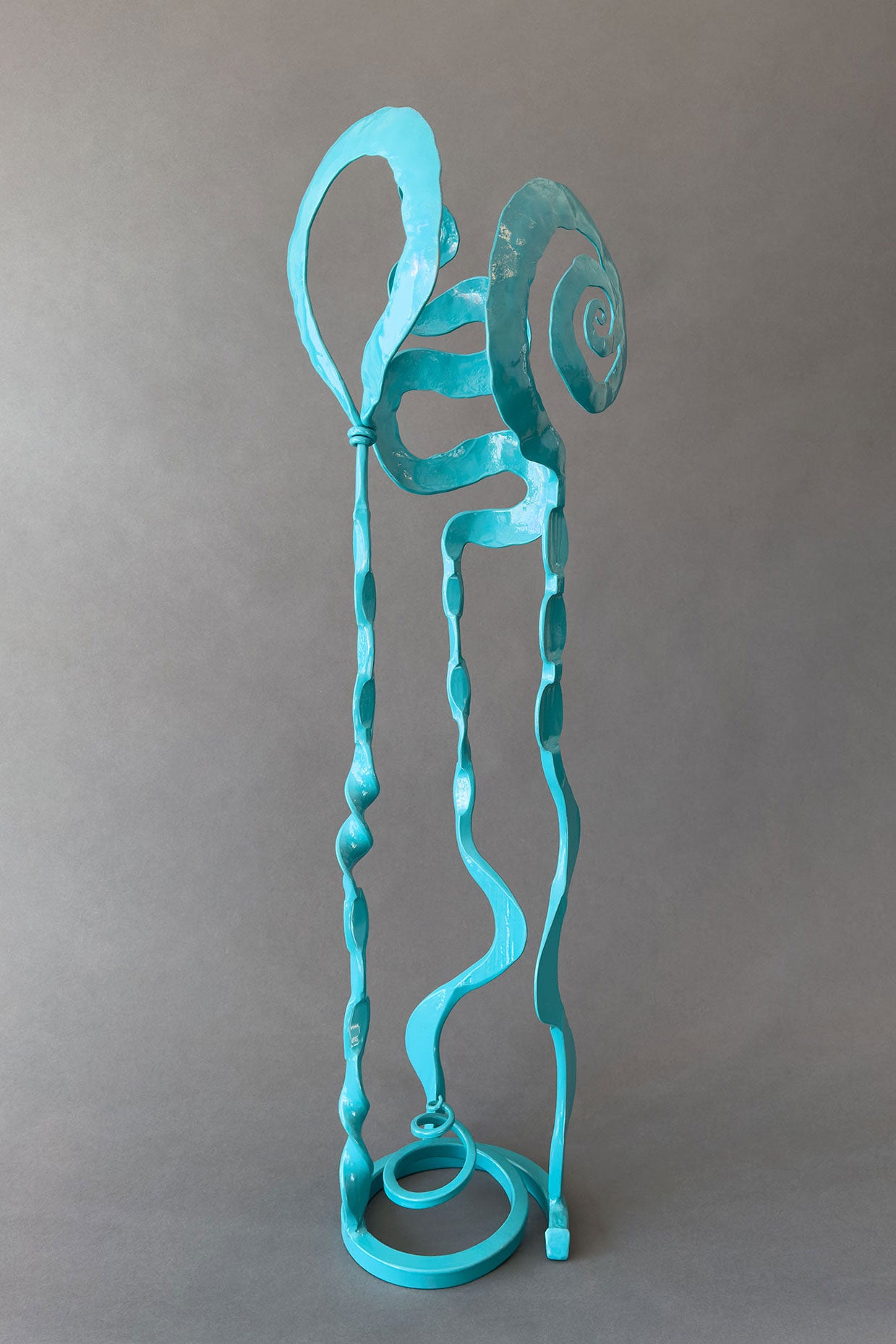 A small turquoise colored garden sculpture that may also be put in the home. Sculpture is made of hand forged steel.