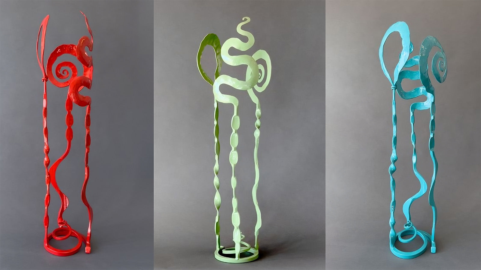 Three small hand forged steel sculptures in a row in the colors red, sage green and turquoise. Baby Blooms by New Mexico blacksmith, Christopher Thomson.