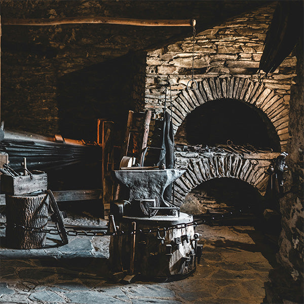 Historical blacksmith shop with old world anvil and blacksmith tools.