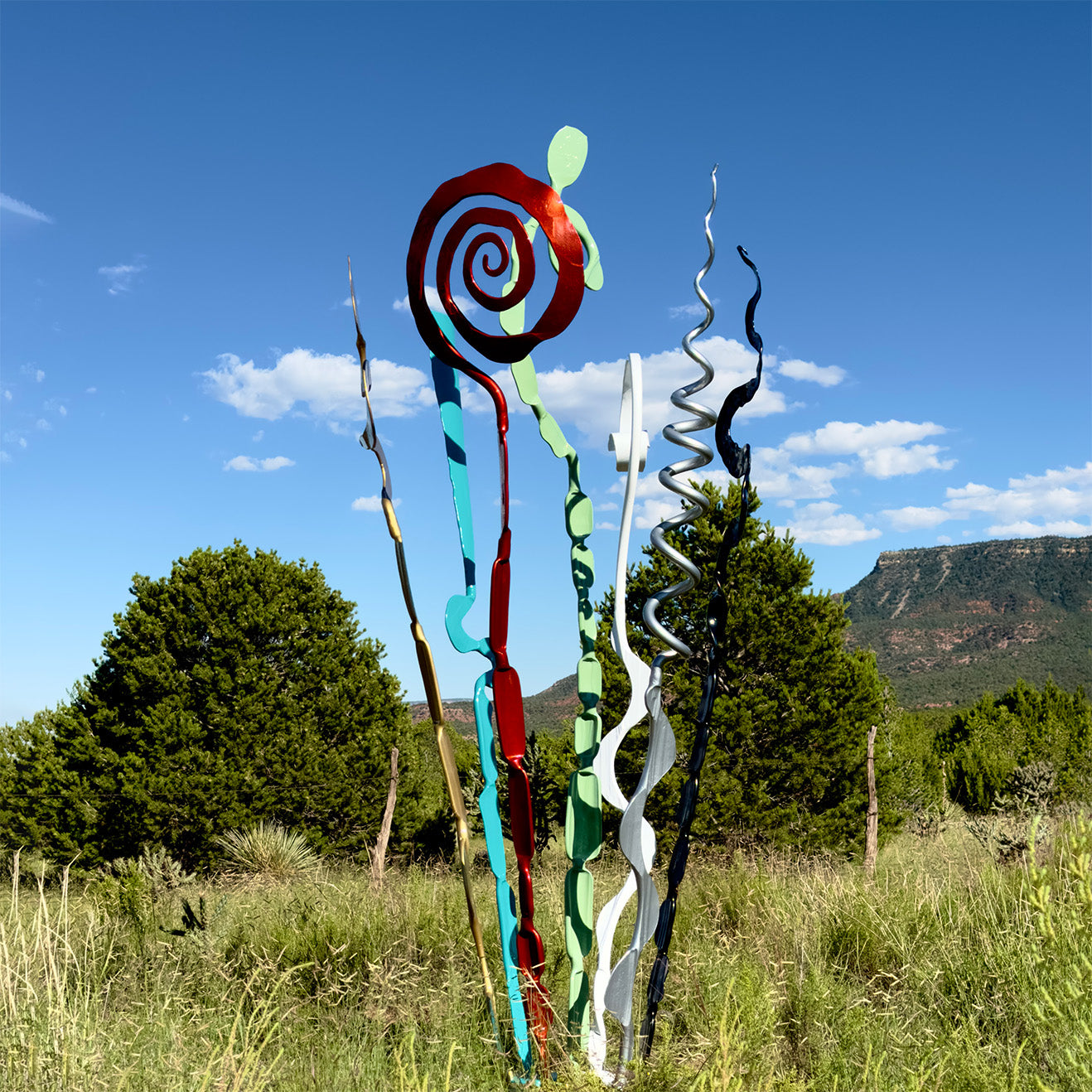 Multi colored abstract steel sculpture in a high desert landscape.