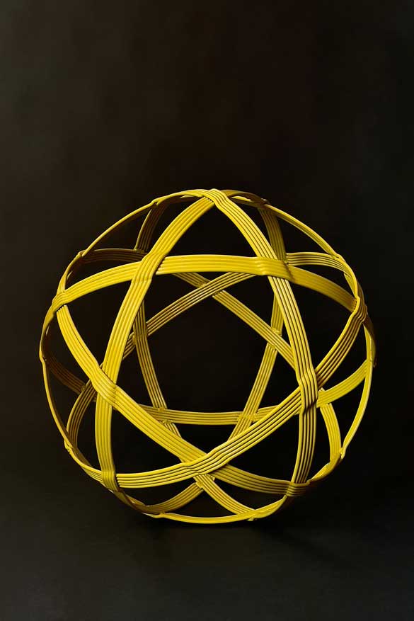 A 25-inch pineapple yellow sphere sculpture in the shape of a chinlone wicker ball.