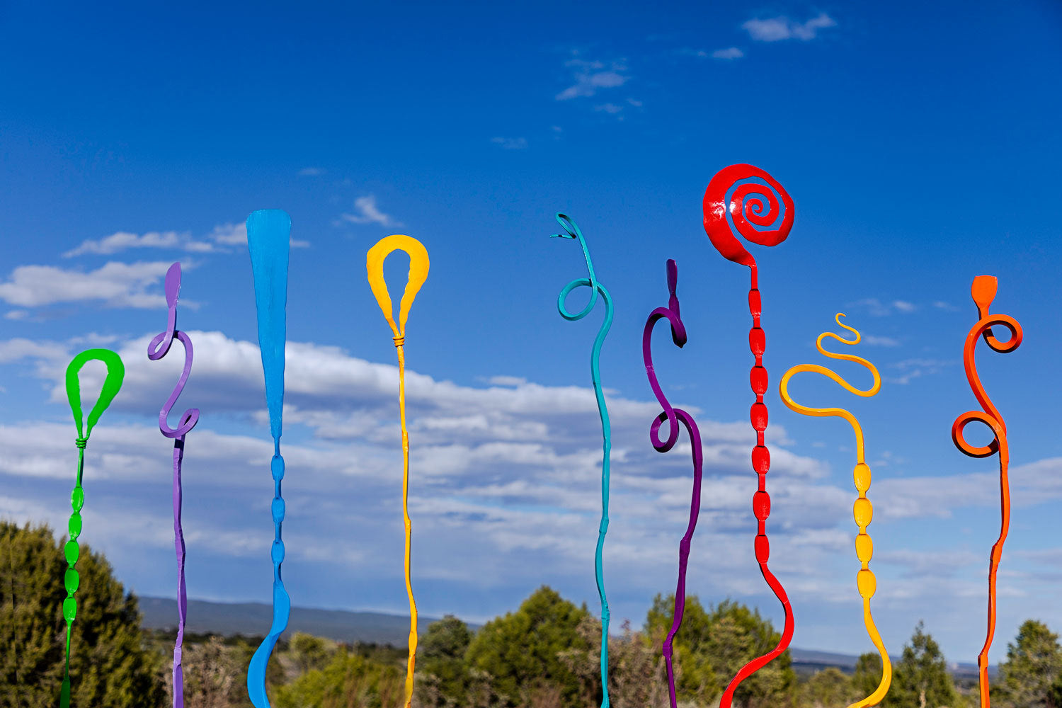 Single Blooms, unique sculptures for landscapes and gardens in many colors on display against a blue sky background.