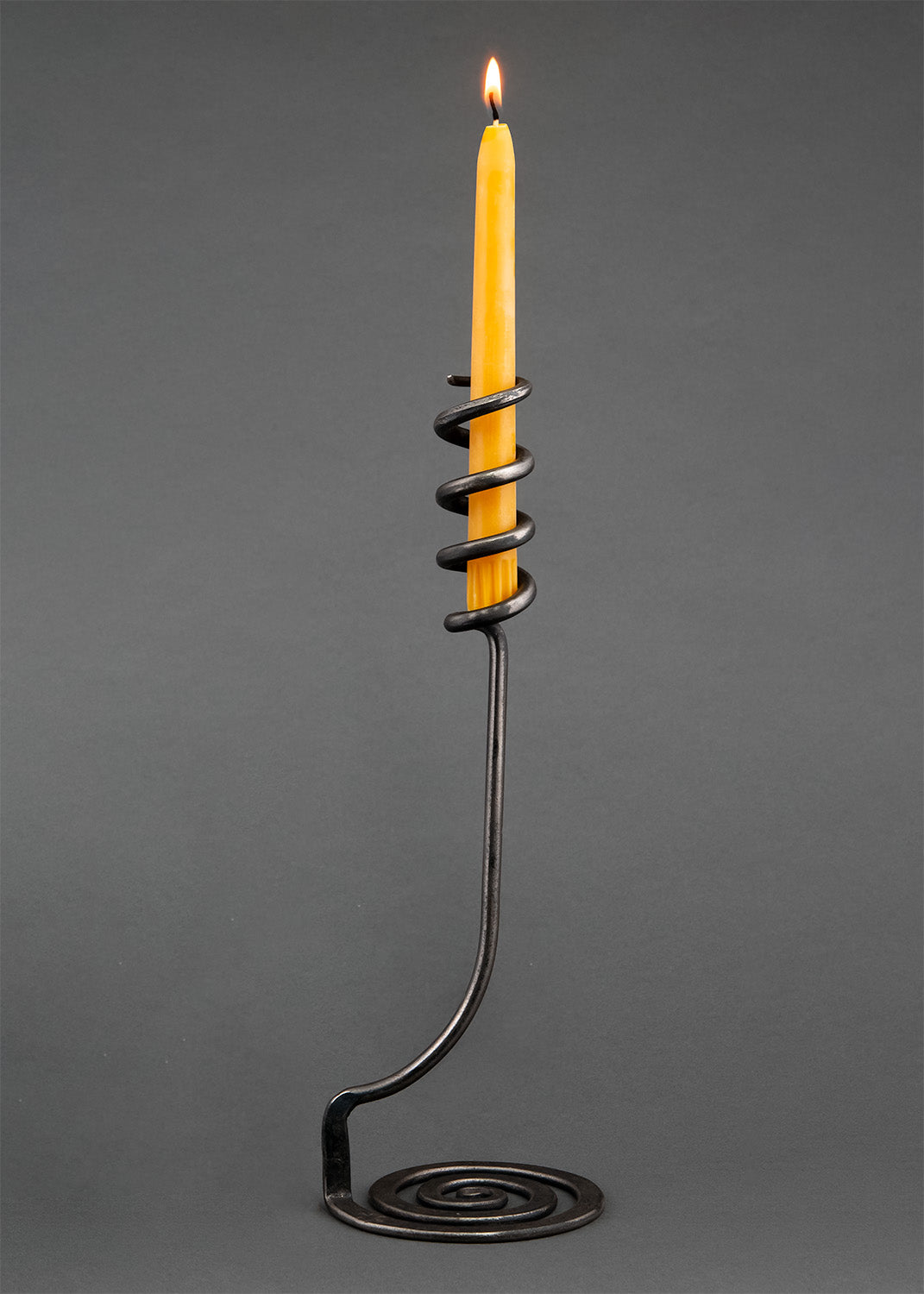 A Single Cosmos Wrought Iron Candle Holder with a taper beeswax candle.