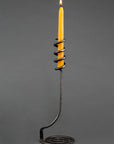 A Single Cosmos Wrought Iron Candle Holder with a taper beeswax candle.