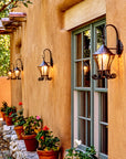 Hanging Iron Wall Lanterns outside on an adobe wall.
