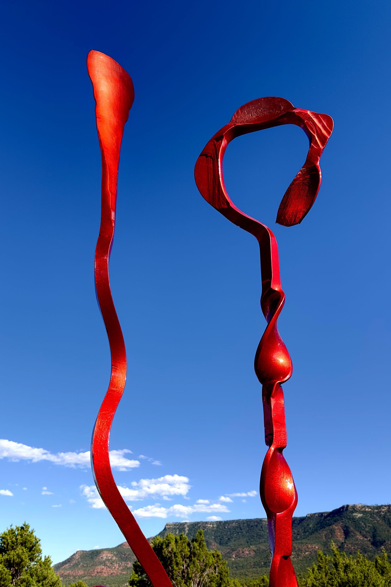 Top half of a copper colored abstract steel sculpture.