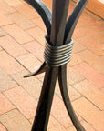 Close-up of the martini bar table's hand-wrapped iron collar binding curved forged legs