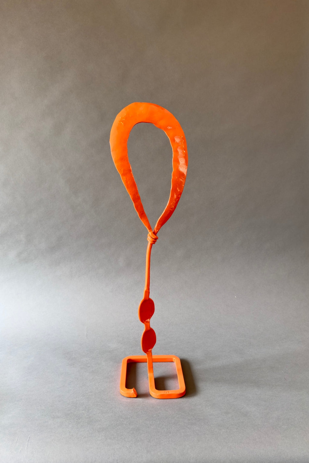 Hand-forged Orange Balloon Mesa Bloom sculpture featuring a single spherical element on a tall stem, mounted on a square base, designed for colorful outdoor garden art.