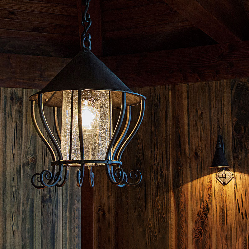 Large blacksmith made wrought iron hanging lantern and an iron entry sconce in the background.