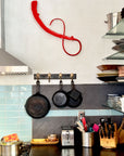 Kitchen counter scene with a red abstract metal wall sculpture.