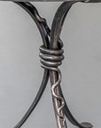 Iron forged rattlesnake wrapped around a wrought iron table base.