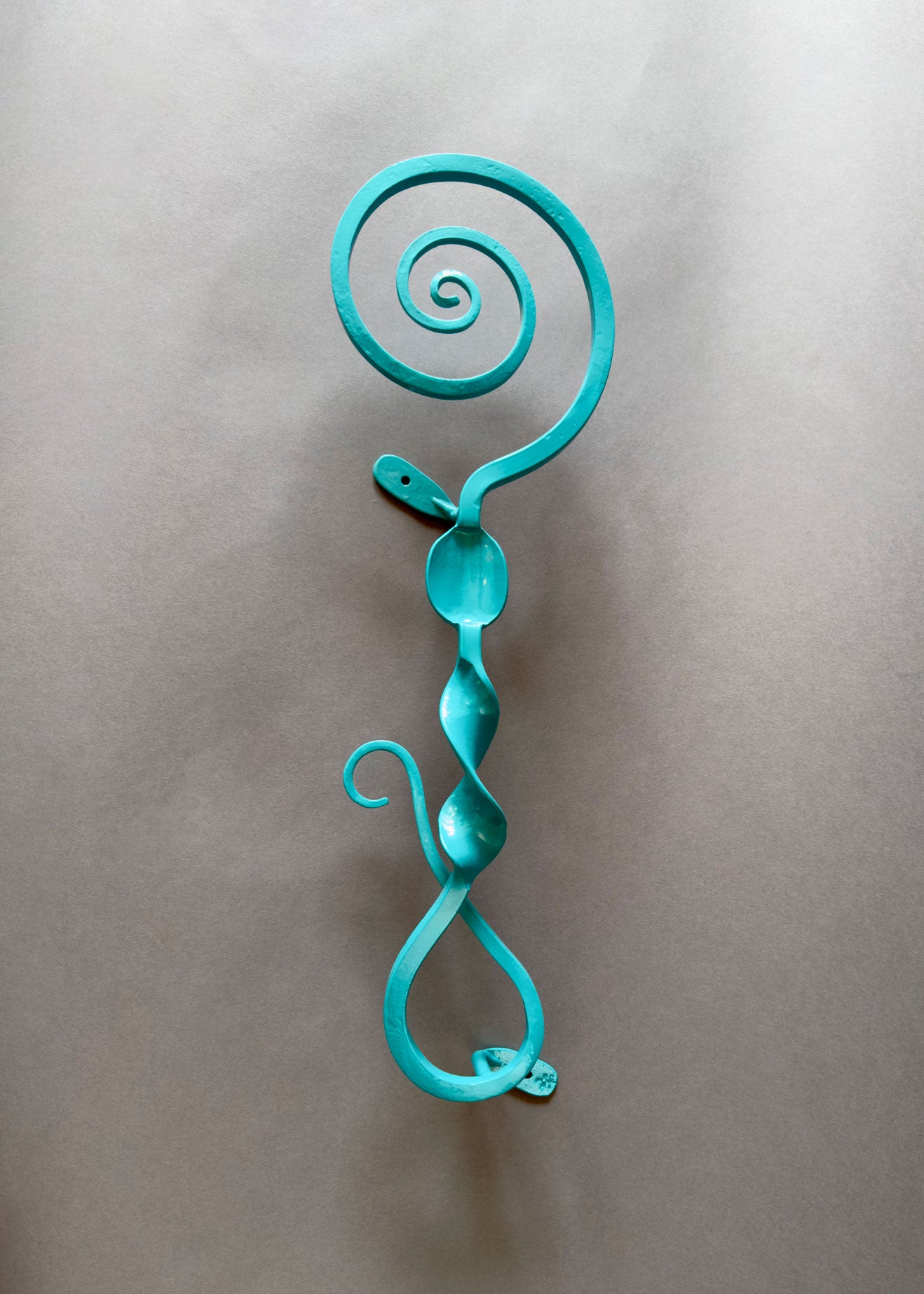 Turquoise metal wall sculpture called Turquoise Maze Wisp Single Musing".