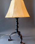Wrought iron lamp with a forged steel vine wrapped around the stem. Shown with a handmade sheepskin shade.