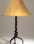 Western Rattlesnake wrought iron lamp with a forged steel rattlesnake wrapped tightly around the base of the light fixture's stem. Shown with a handmade sheepskin shade.