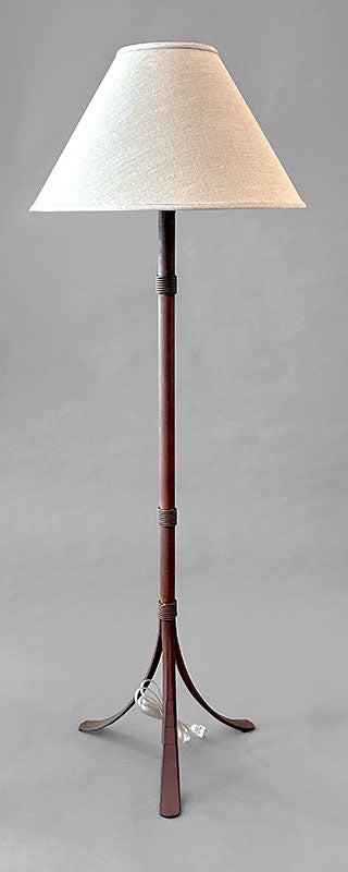 Rustic wrought iron floor lamp made from hand forged steel and paired with a woven linen shade.