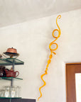 Yellow metal wall sculpture hanging in a kitchen.