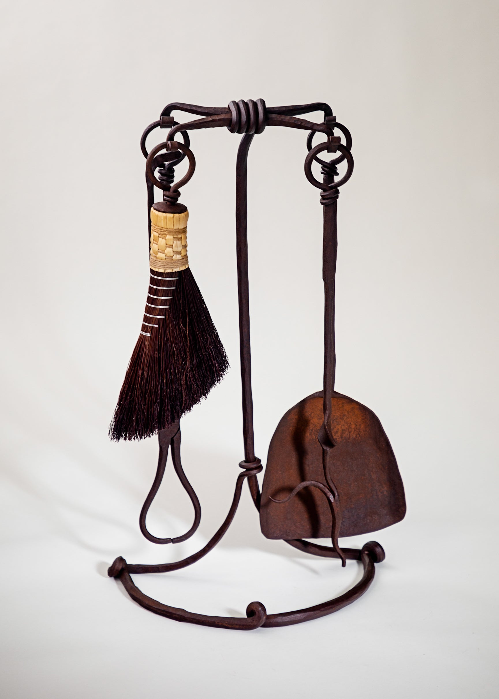 Wrought iron fireplace tool set with a natural rust finish. Standing fire tool set with four fire tools including a broom, fire poker, shovel and tongs.