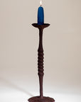 Iron Candle Holder with a twisted spiral stem and wide base, shown in a rust finish.