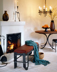 Fireside scene with wrought iron furniture and elegant iron home decor by Christopher Thomson, showcasing his hand forge Vessel Bench.