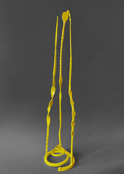 Pineapple yellow colored forged steel sculpture with three long tendrils coming up from a spiral base.