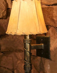A small, rustic, forged steel Torch Wall Sconce with a rawhide sheepskin shade.