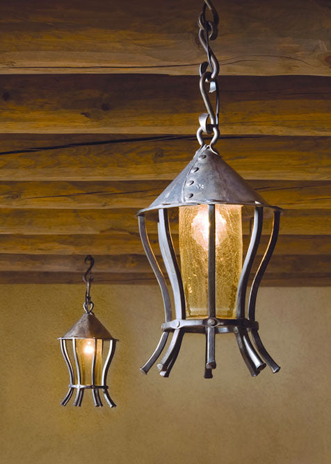 Large hand forged Contemporary Pendants hanging from the ceiling on s-hook chains.