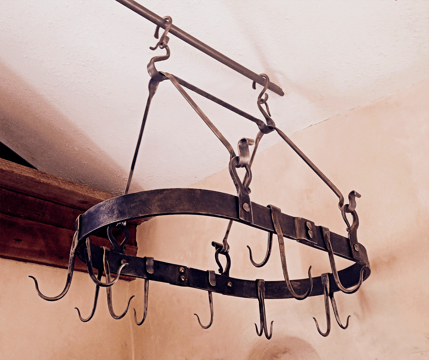 Kitchen Wrought Iron Pot Rack made  by Santa Fe blacksmith, Christopher Thomson Ironworks. It is oval shaped with double sided hooks for pots and pans.