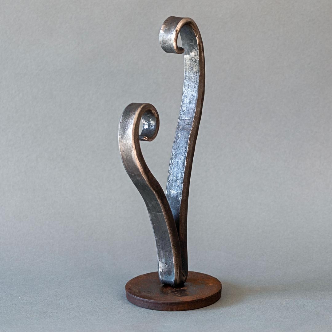 Side view of a small wrought iron heart sculpture.