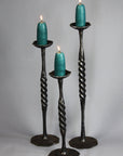 Three Spiral Wrought Iron Candlestick Holders made by blacksmith artist, Christopher Thomson - shown with large candles.