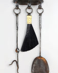 Wrought iron wall mounted fireplace tool set with a hand forged fire poker, broom and shovel.