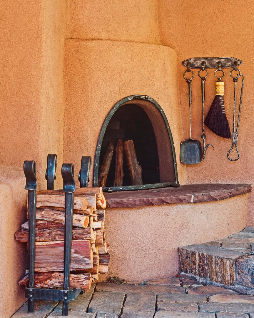 Wrought iron fireplace tools showing a wall mounted fireplace tool set, a wrought iron log holder, and custom wrought iron fire screen.