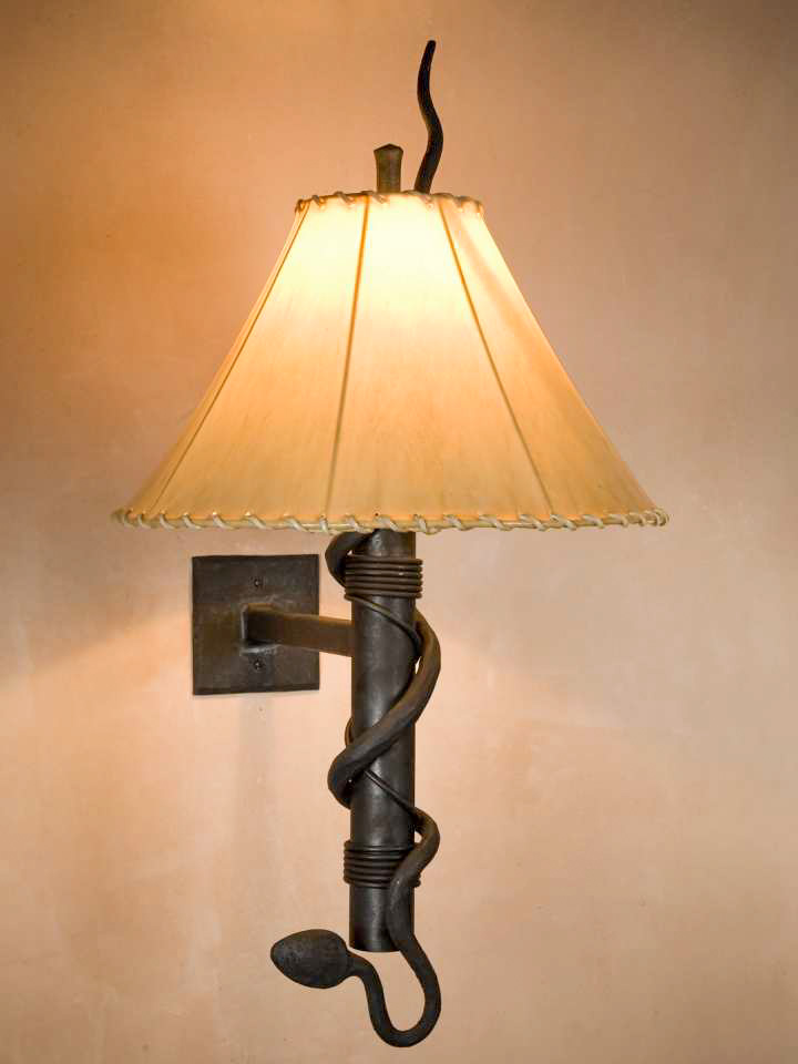 Wrought iron wall sconce with a rattlesnake design and a sheepskin shade.