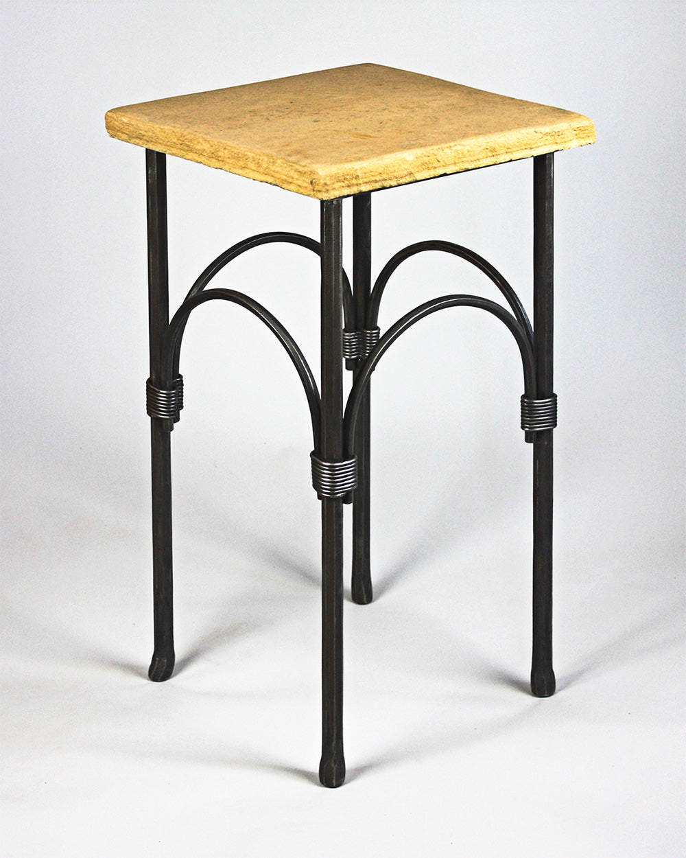 A hand forged steel pedestal table with a flagstone top. Wrought iron design.