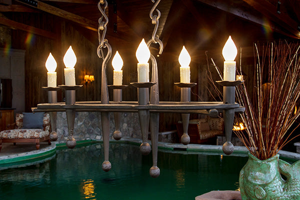 Wrought iron chandelier hanging over an indoor koi pond.