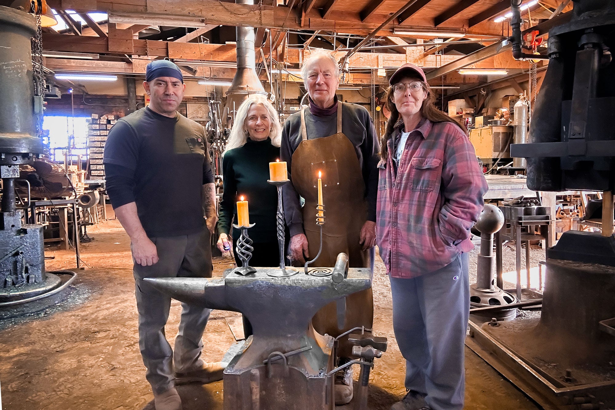 The Christopher Thomson Ironworks team gathered around the anvil in their San Jose, New Mexico blacksmith shop