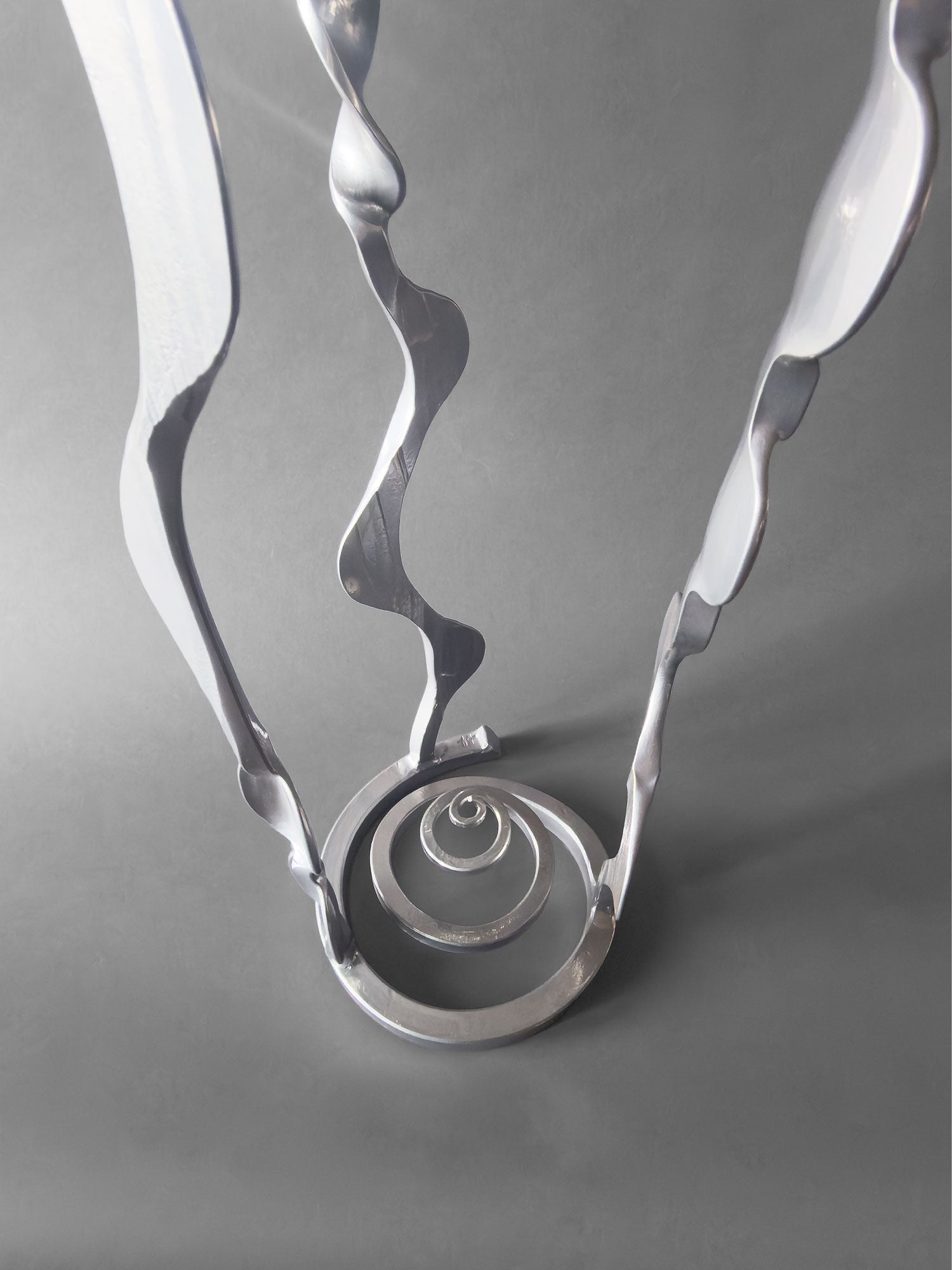 Spiral sculpture base with a powder coated chrome finish.