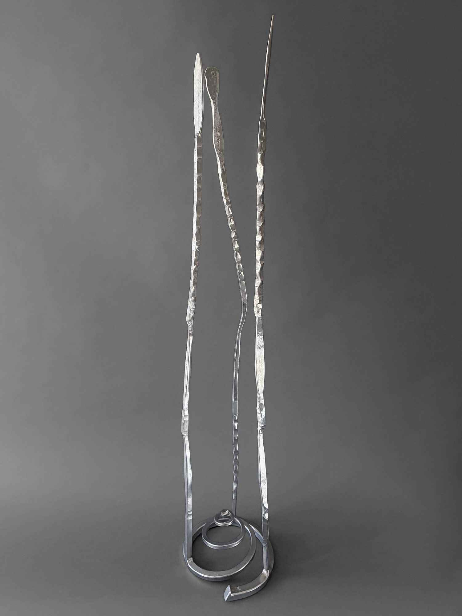 Chrome Baby Pajo hand forged steel sculpture, side view showing uneven height and curve of the three forms