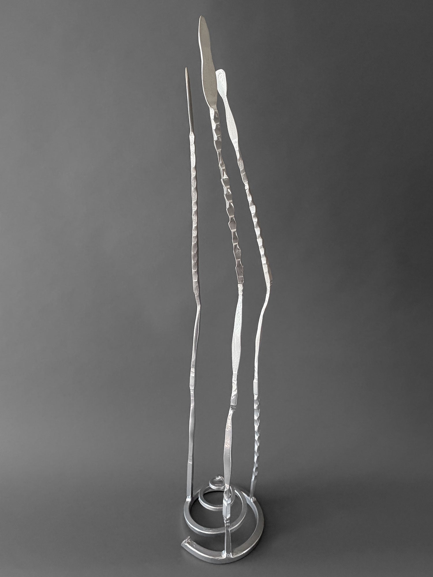Chrome Baby Paho hand forged steel sculpture, side view showing uneven height and curve of the three forms