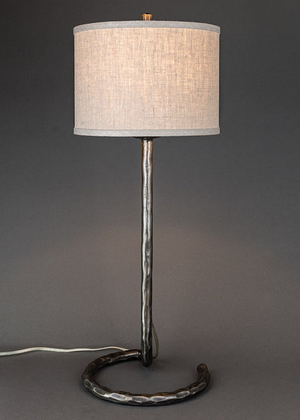 High end wrought iron lamp with a circle base and a contemporary linen drum shade. Lamp made by blacksmith Christopher Thompson Ironworks.