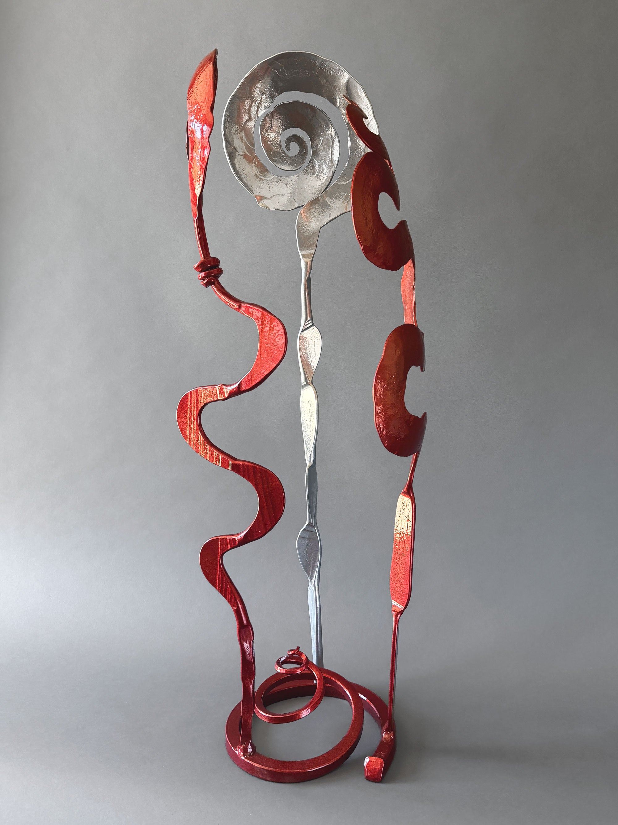 Abstract steel Baby Bloom sculpture showcasing intersecting chrome and metallic copper elements that create changing perspectives from every viewing angle.