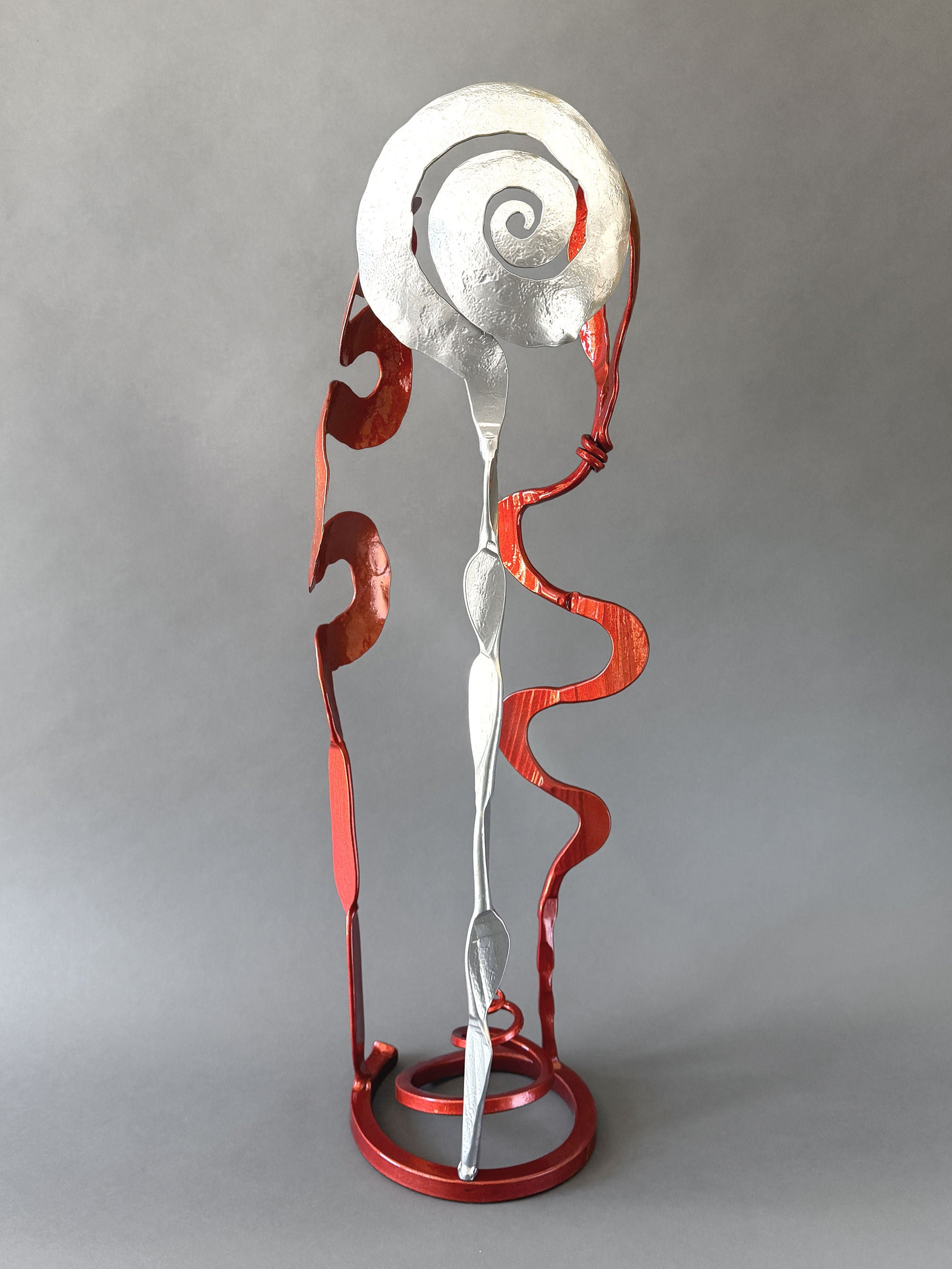 Copper &amp; Chrome Baby Bloom sculpture featuring flowing abstract steel forms with reflective chrome and metallic copper finishes on a circular free-standing base.