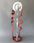 Copper & Chrome Baby Bloom sculpture featuring flowing abstract steel forms with reflective chrome and metallic copper finishes on a circular free-standing base.