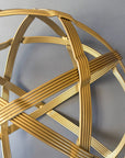 Close-up of gold powder-coated steel strands bending over and under where two bands cross