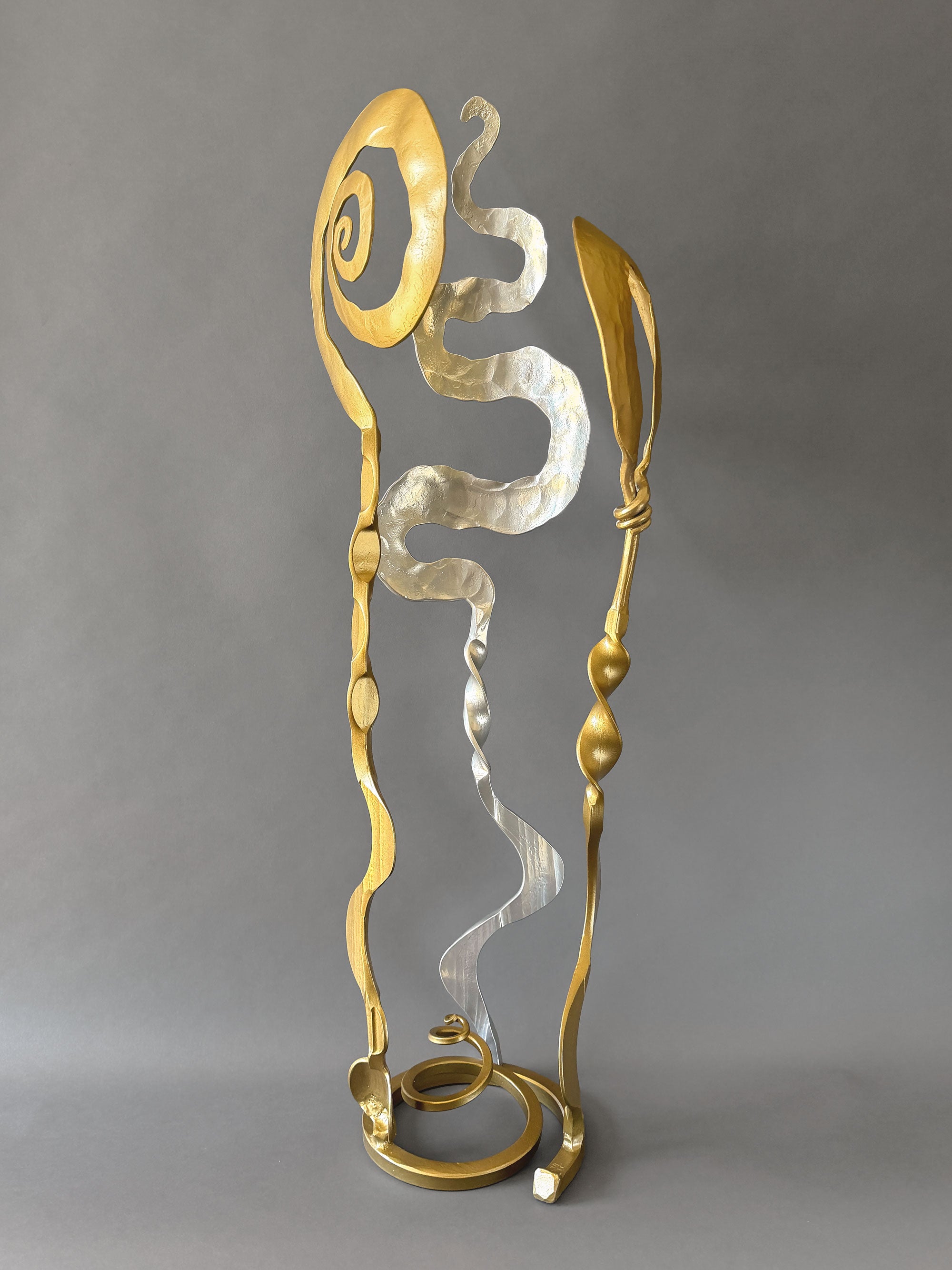 Contemporary steel Baby Bloom sculpture with reflective chrome center and gold forged elements displayed against a neutral background.