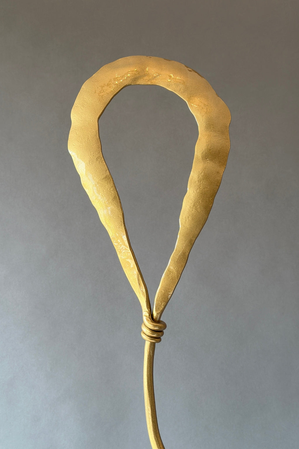 Gold metal balloon shape at the top of a sculpture.