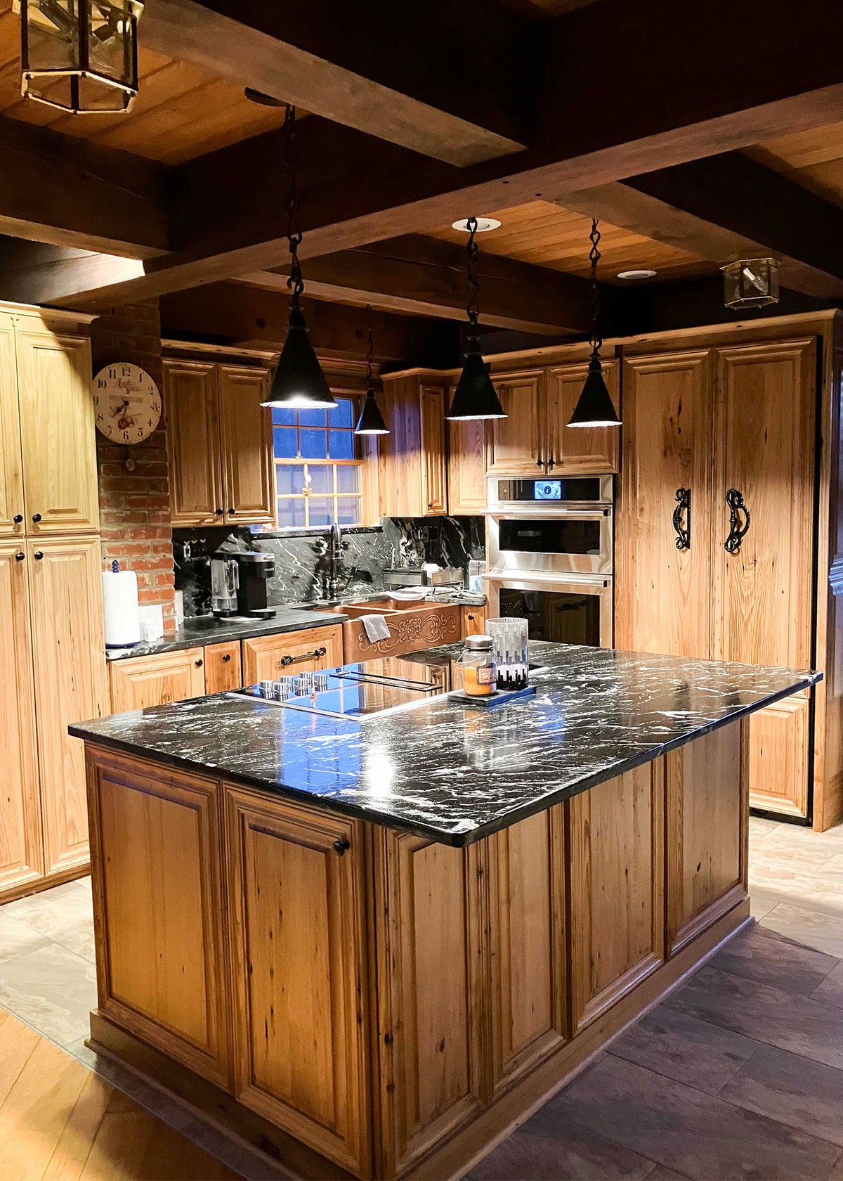 Custom hanging wrought iron pendant lights over a kitchen island. 