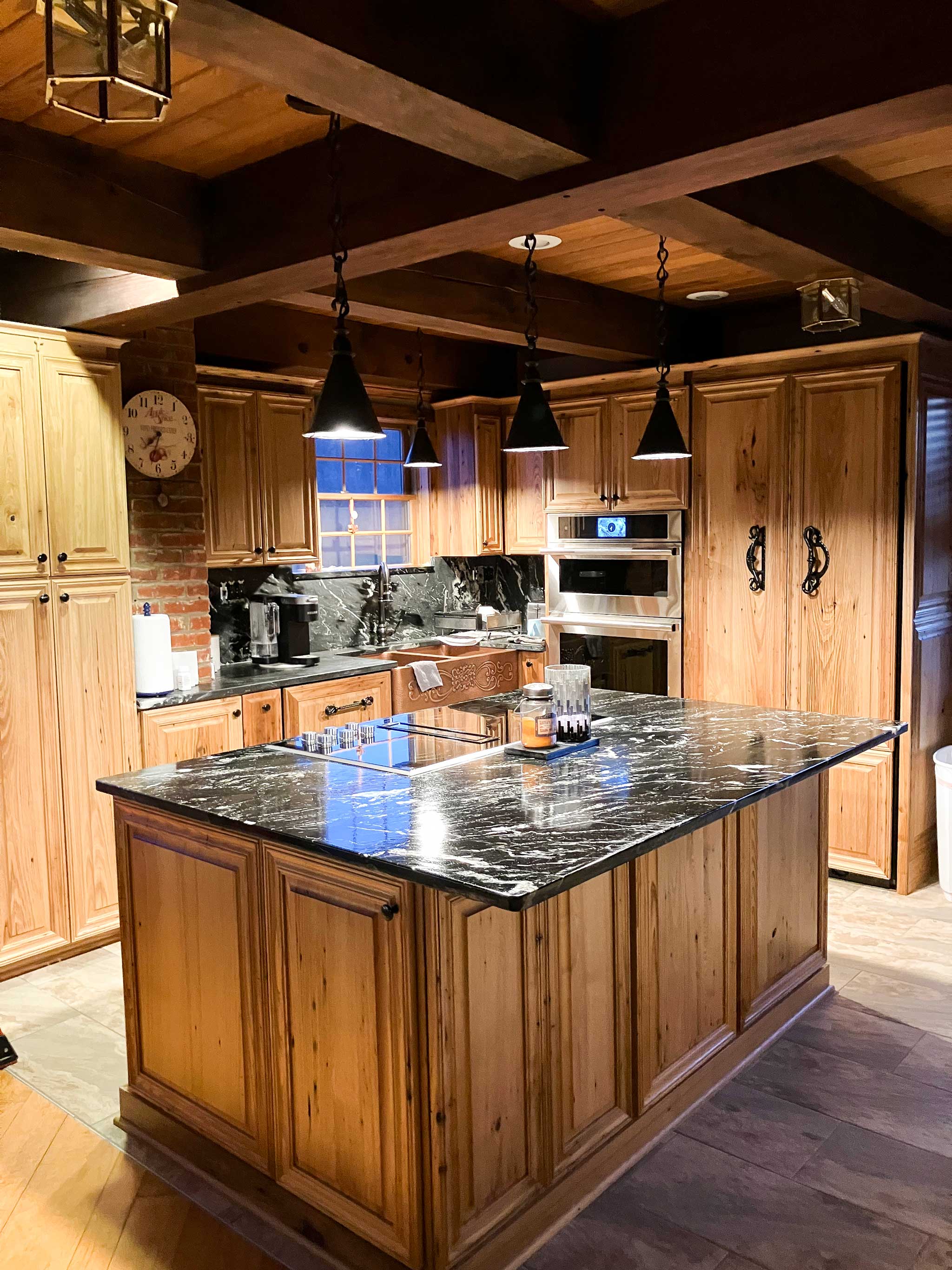 Custom hanging wrought iron pendant lights over a kitchen island. 