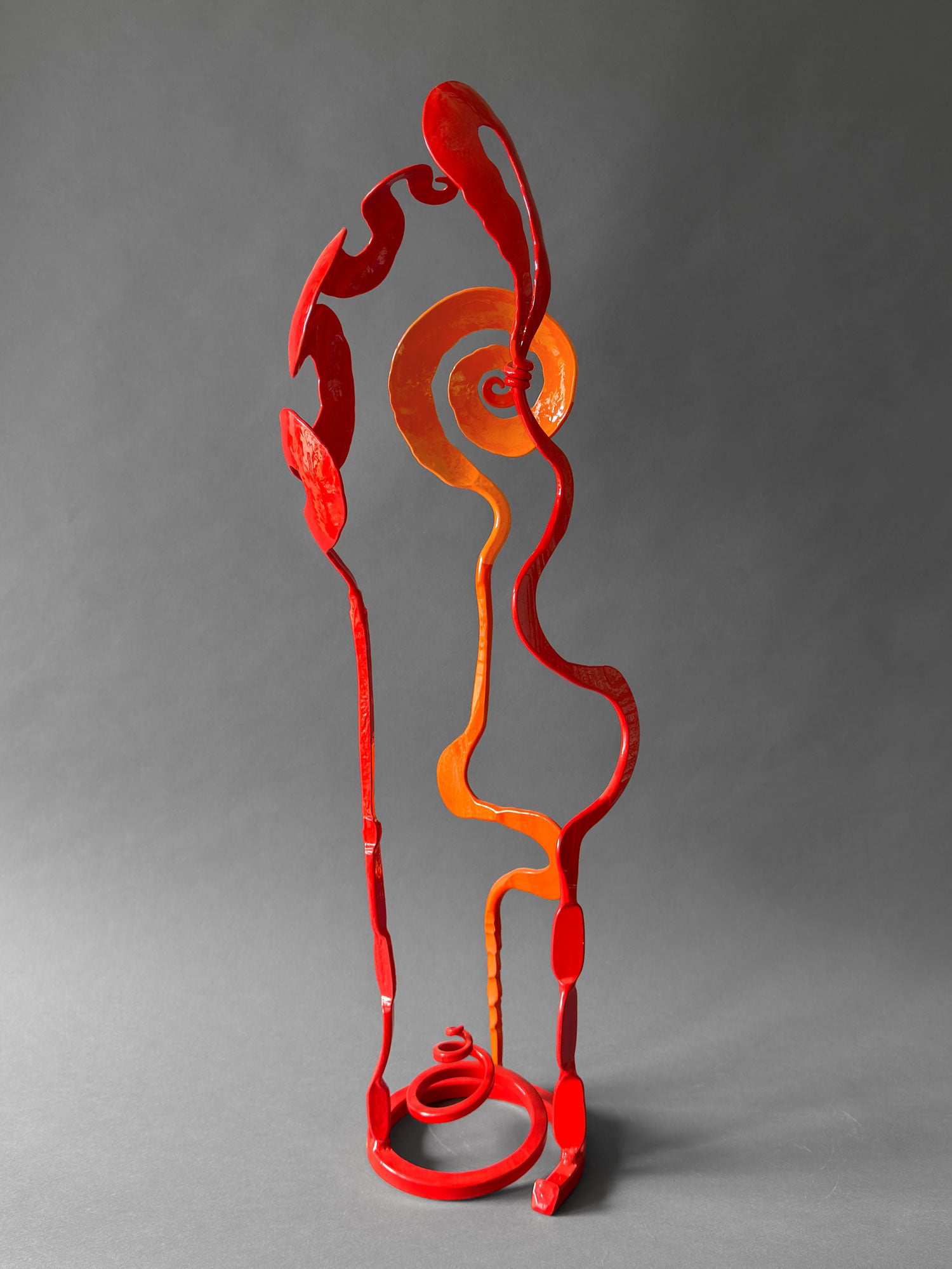 Back view of orange and red Baby Bloom steel sculpture showing red Loop and Meander forms, one of a kind, hand forged in New Mexico