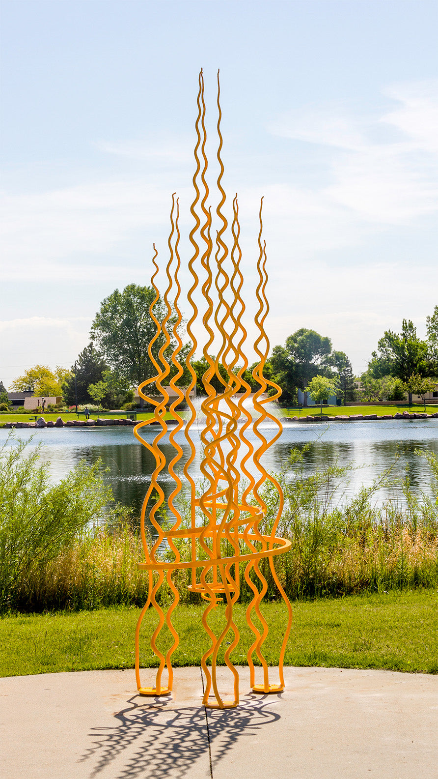 Monumental yellow sculpture made from hand forged steel. Abstract sculpture with 14 spirals reaching upwards.